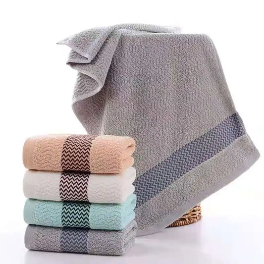 Stack of folded towels with a large gray towel on a white background