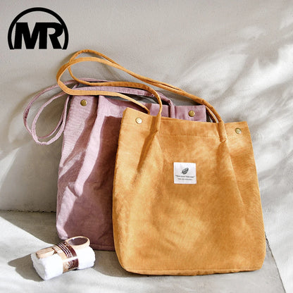 Two tote bags, one brown and one pink, with a visible brand logo on a light background.
