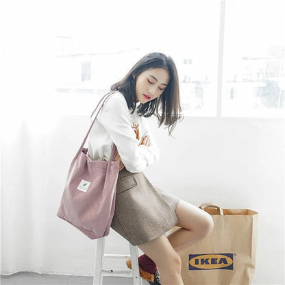 Woman holding a pink tote bag with an IKEA bag on the floor