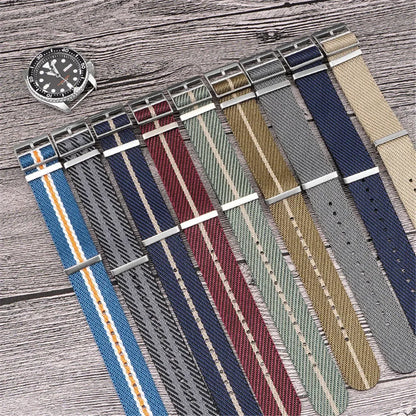 Set of various watch straps on a wooden surface with a watch on the left.