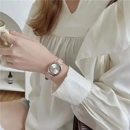 Person wearing a pink watch with a white blouse