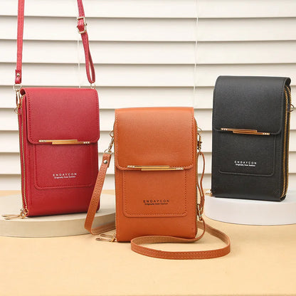 Three small handbags in red, orange, and black on a neutral background