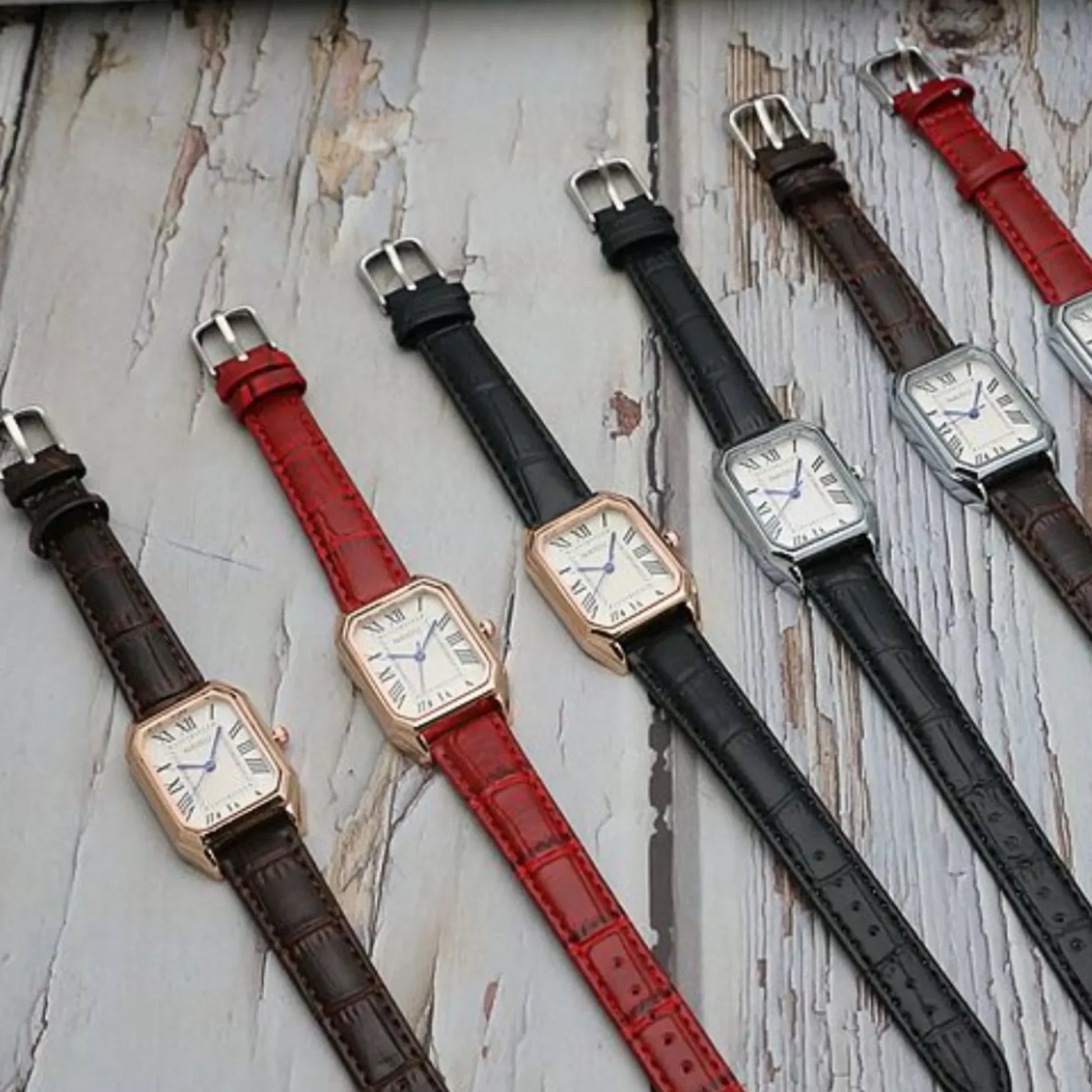 Set of watches with different colored straps on a textured surface
