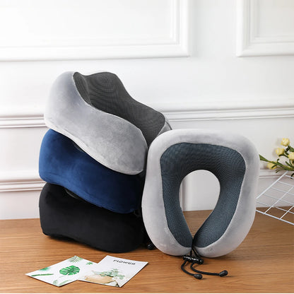 Stack of travel neck pillows on a wooden surface with a white wall background