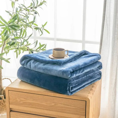 Blue blanket on a wooden surface with a plant in the background