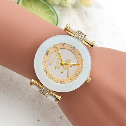 Gold and white watch on a wrist with a light background