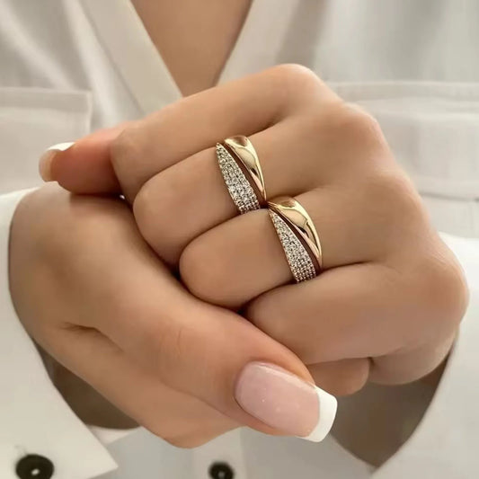 Close-up of a hand wearing two gold rings with a white background