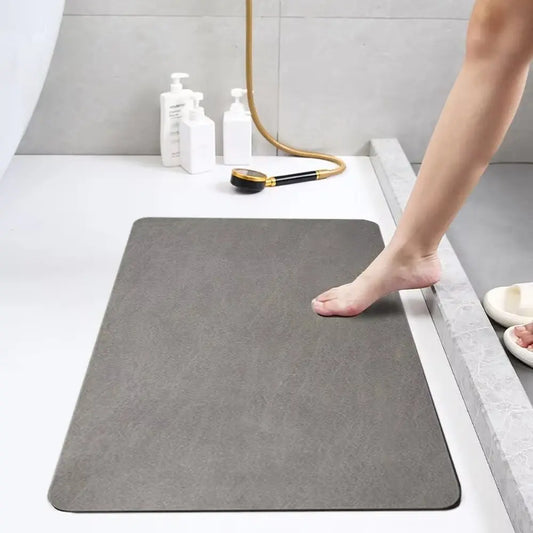 Person stepping onto a gray bath mat in a bathroom setting.