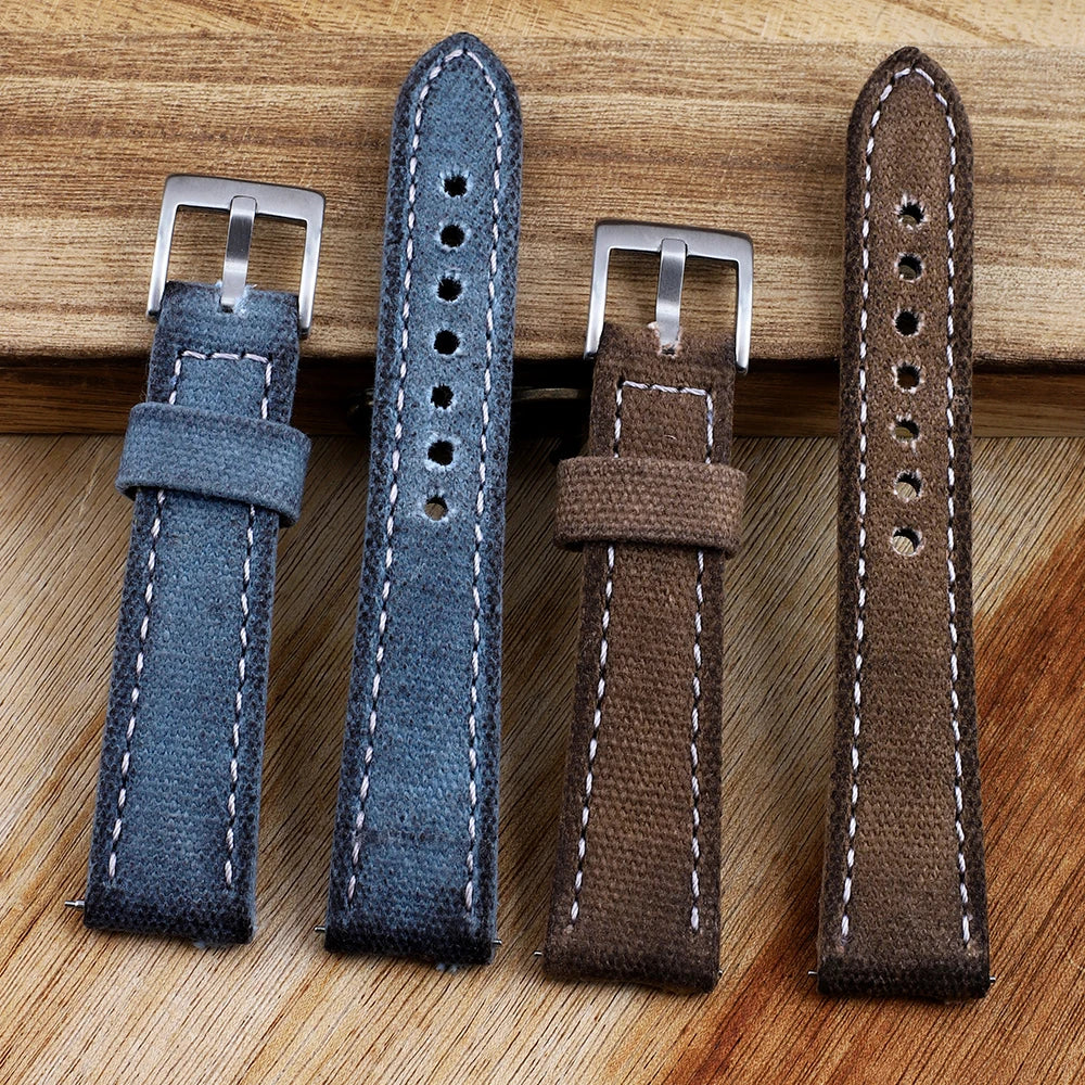 Two blue and two brown watch straps with silver buckles on a wooden surface
