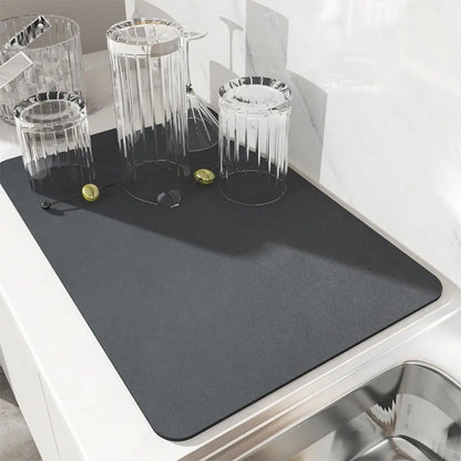 Gray placemat on a kitchen counter with glasses and coins