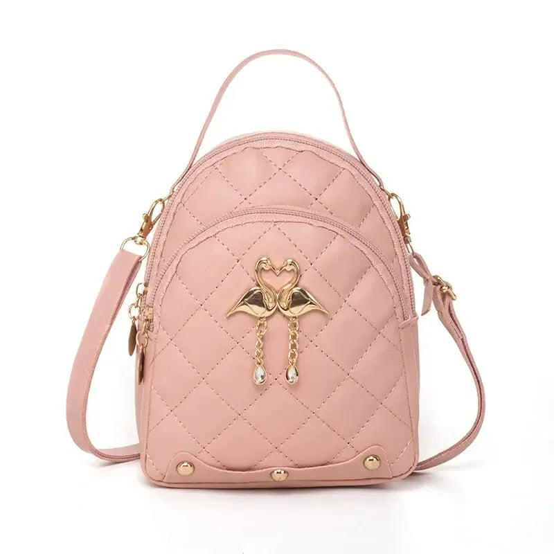 Pink quilted backpack with gold accents on a white background