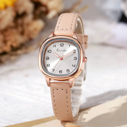 Wristwatch with beige strap and rose gold case on a light background