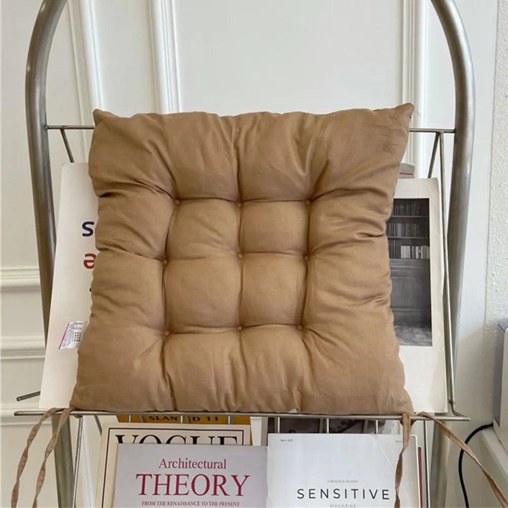 Brown cushion on a metal chair with books in the background