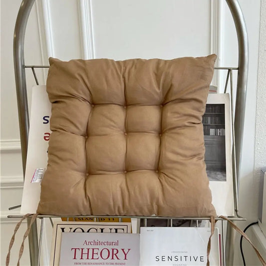 Brown cushion on a metal chair with books in the background