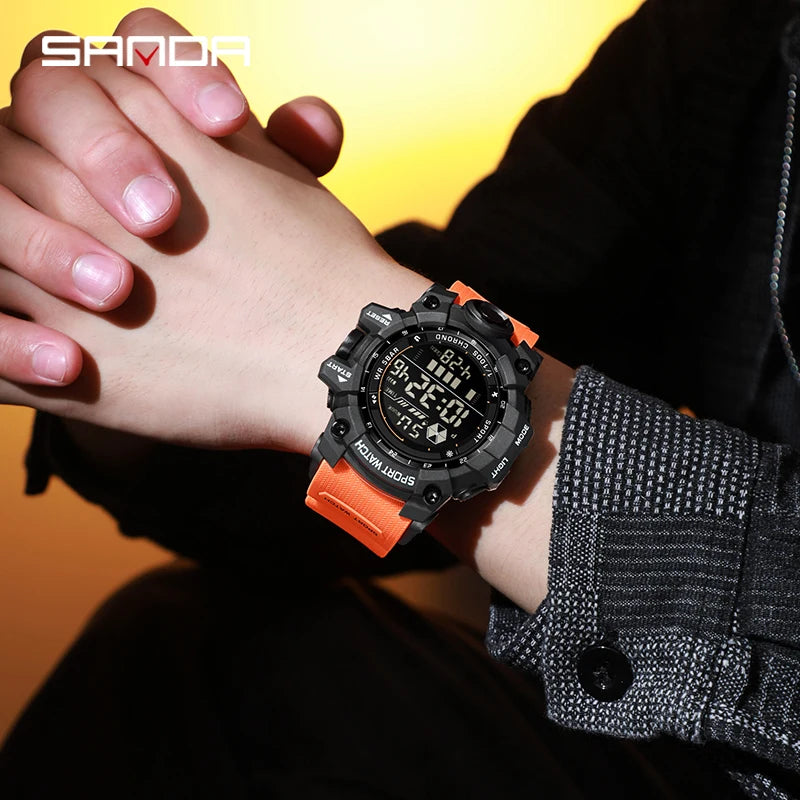 Person wearing a black and orange digital watch with a blurred background