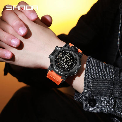 Person wearing a black and orange digital watch with a blurred background