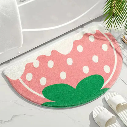 Pink polka dot watermelon-shaped rug on a white floor with white slippers nearby.