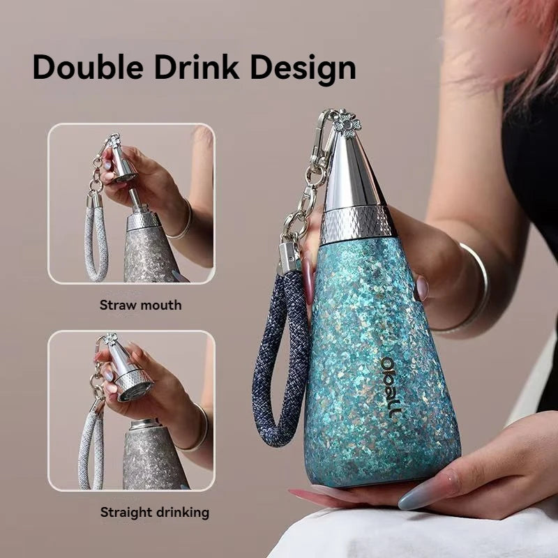Blue glittery drink container with straw and straight drinking options, held by a person.