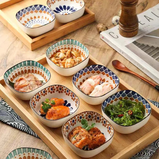 Set of small ceramic bowls with decorative patterns on a wooden tray.