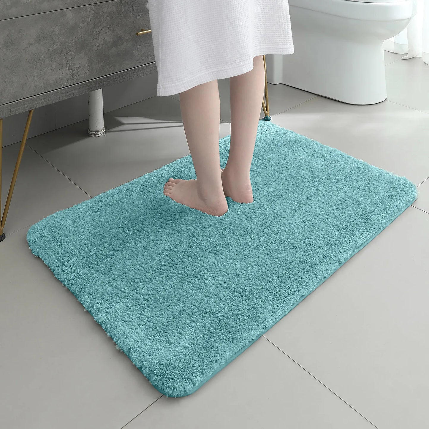 Person standing on a teal bath mat in a bathroom setting