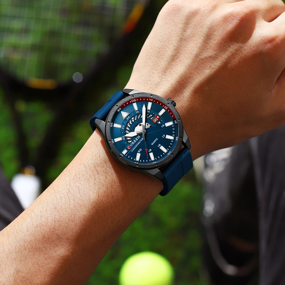Person wearing a blue watch with a tennis court in the background