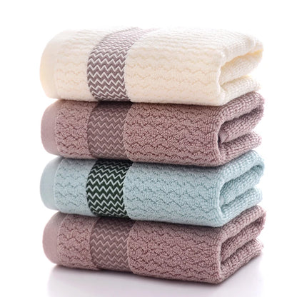 Stack of folded towels in white, pink, blue, and purple on a white background