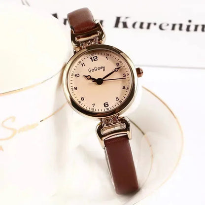 Watch with brown strap and rose gold case on a white background