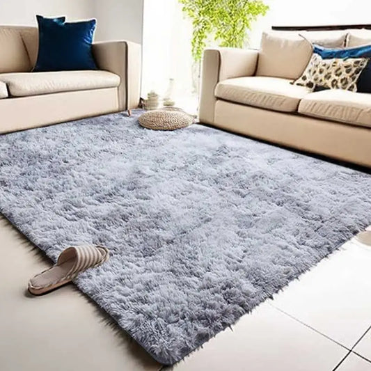 Gray shaggy rug in a living room with beige sofa and blue pillow.