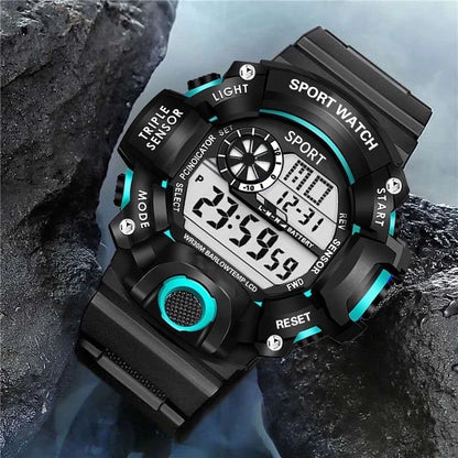 Digital sports watch with black and blue design on a rocky background