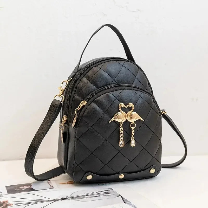 Black quilted handbag with gold accents on a light background