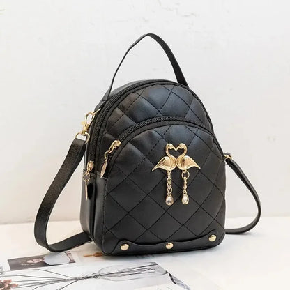 Black quilted handbag with gold accents on a light background