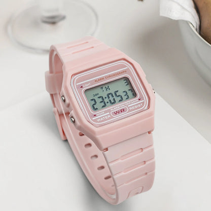 Pink digital watch on a white surface