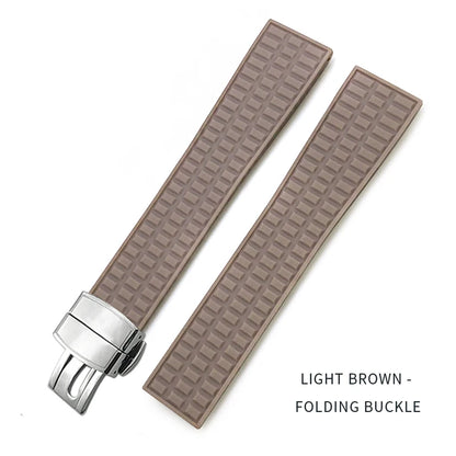 Light brown textured watch strap with silver folding buckle on a white background