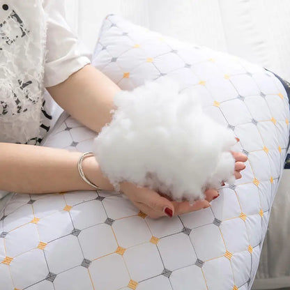 Person holding a white cloud-shaped pillow with a geometric patterned surface.