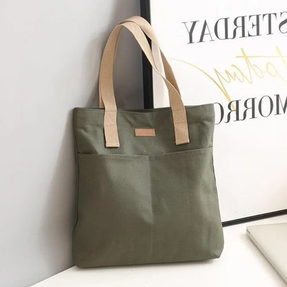 Green tote bag with beige handles on a white surface