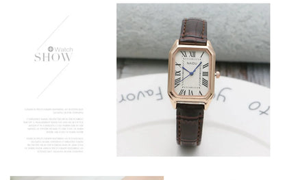 Watch with brown leather strap on a white surface