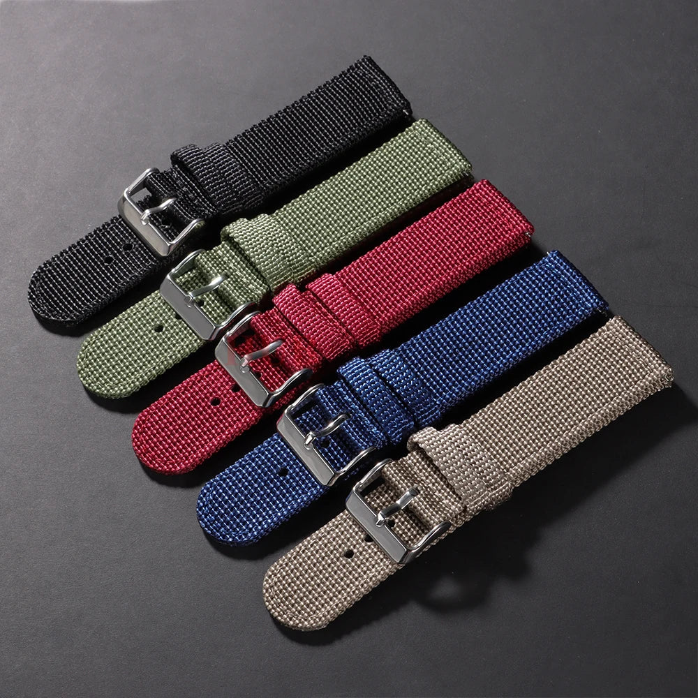 Set of five woven watch straps in black, green, red, blue, and beige on a dark gray background.