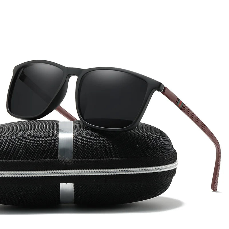 Black sunglasses with brown accents on a black case against a white background