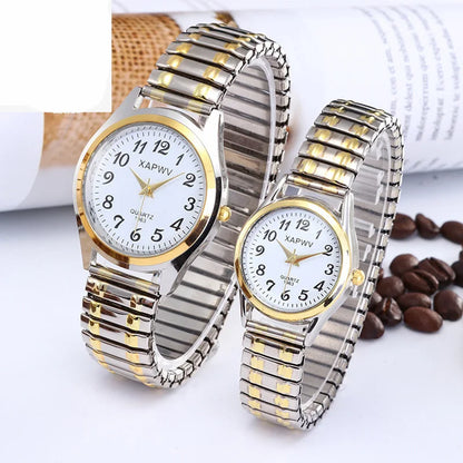 Two silver and gold wristwatches on a white surface with coffee beans.
