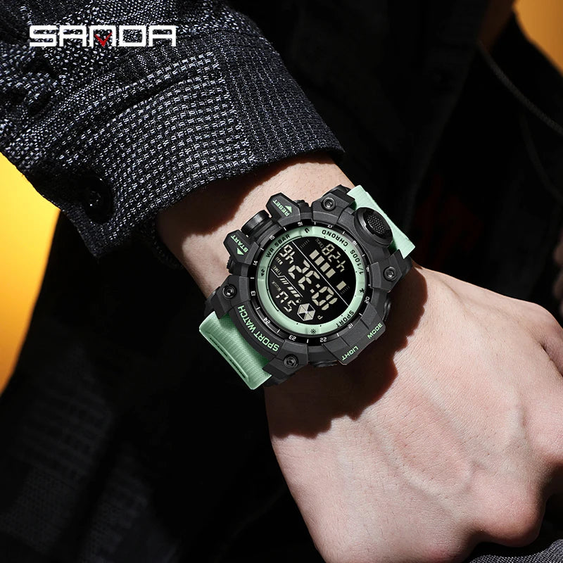 Digital watch with green strap on a wrist, brand 'SANDA' visible
