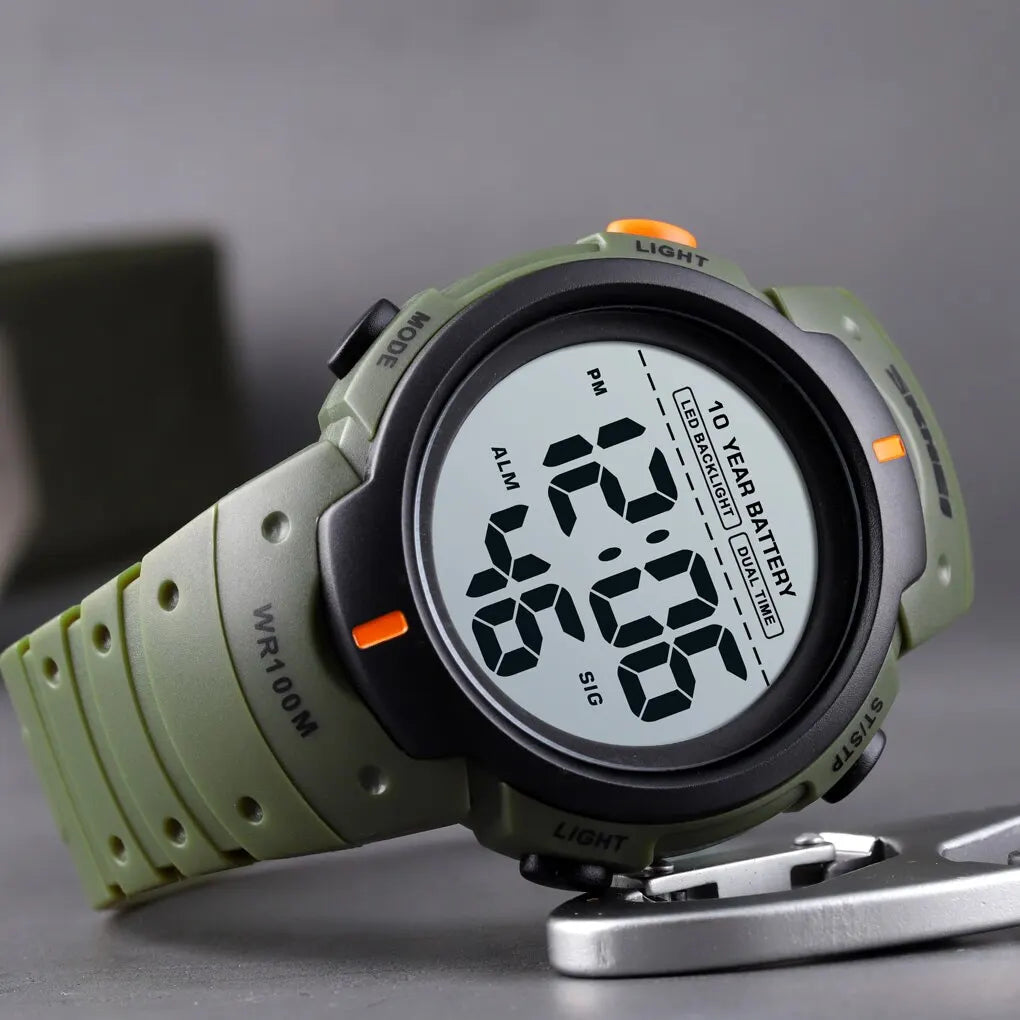 Digital watch with green strap on a gray background