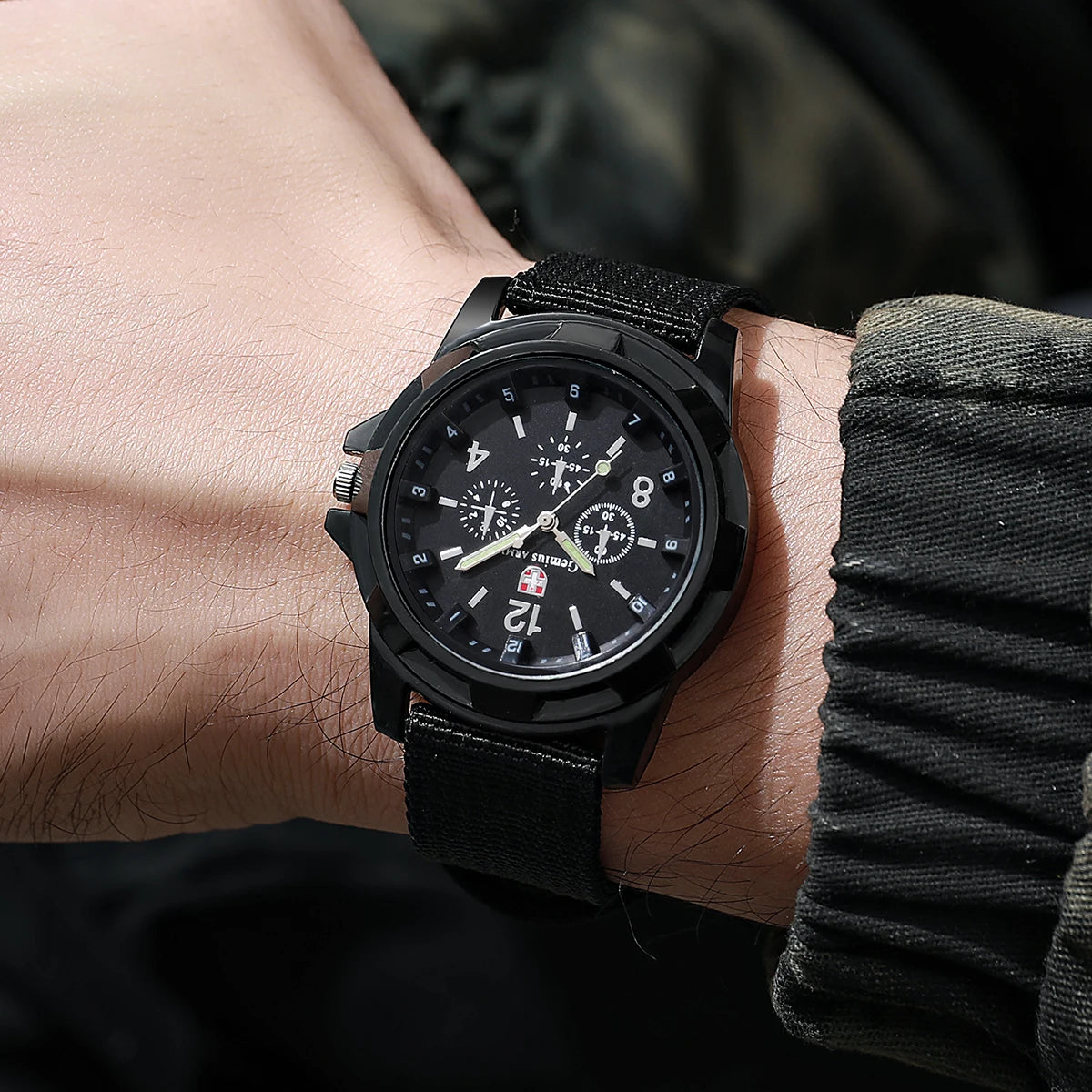 Black wristwatch on a person's wrist with a blurred background