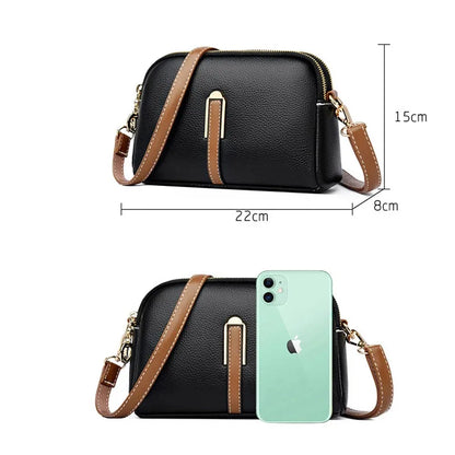 Black handbag with brown strap and gold zipper, shown with dimensions and an iPhone for scale.