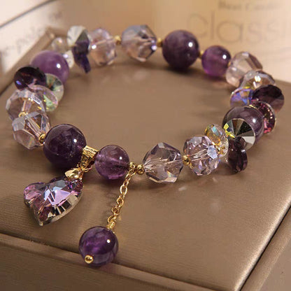 Multicolored beaded bracelet with a heart charm on a beige surface