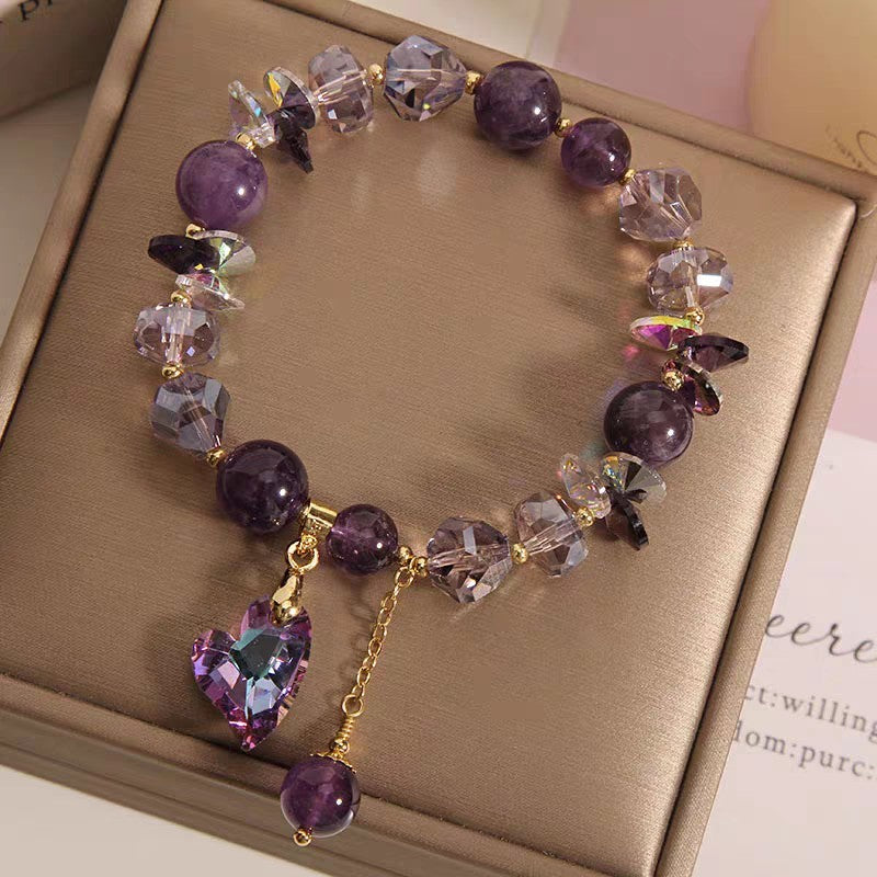 Purple beaded bracelet with a heart charm on a brown surface